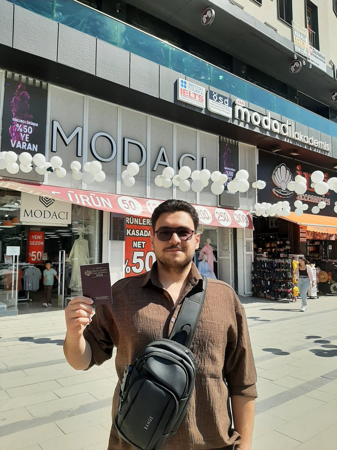 Erfan Khadiv holding his passport in front of the British Council IELTS test centre in Van, Turkey, just before his exam